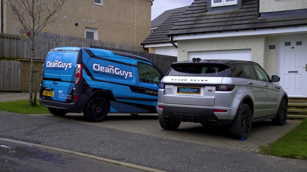 The Clean Guys branded van parked on a Glasgow driveway beside a freshly cleaned silver Range Rover